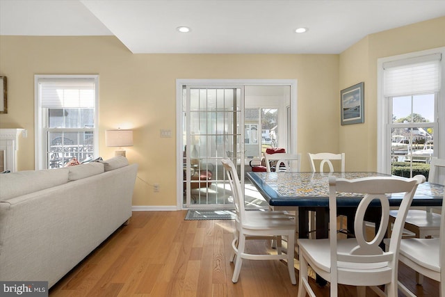 dining space with recessed lighting, light wood-type flooring, plenty of natural light, and baseboards