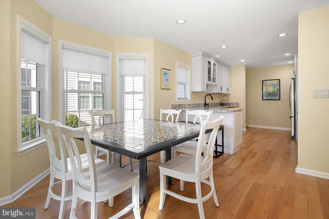 dining area featuring recessed lighting, baseboards, and light wood finished floors