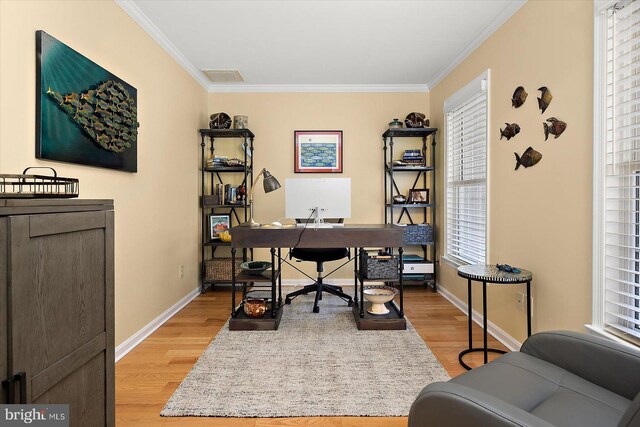 office area with visible vents, light wood-type flooring, baseboards, and ornamental molding