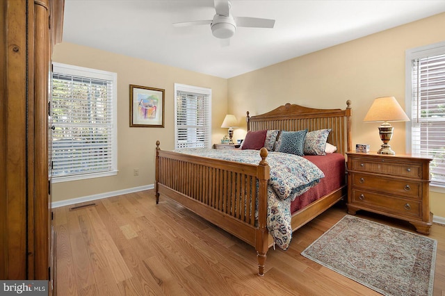 bedroom featuring light wood-type flooring, baseboards, visible vents, and a ceiling fan