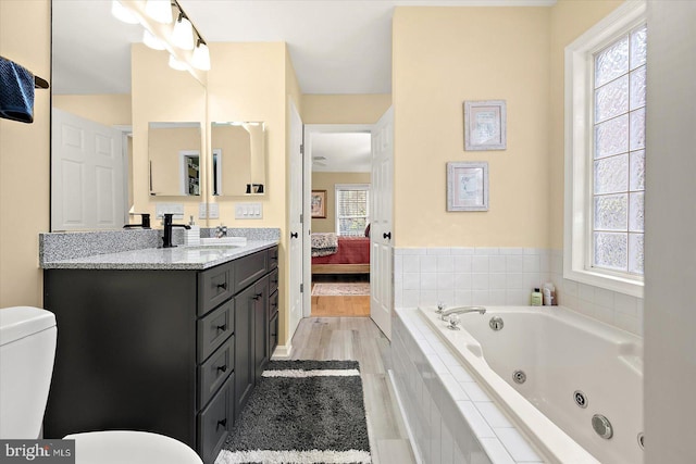 bathroom with toilet, a healthy amount of sunlight, and a whirlpool tub