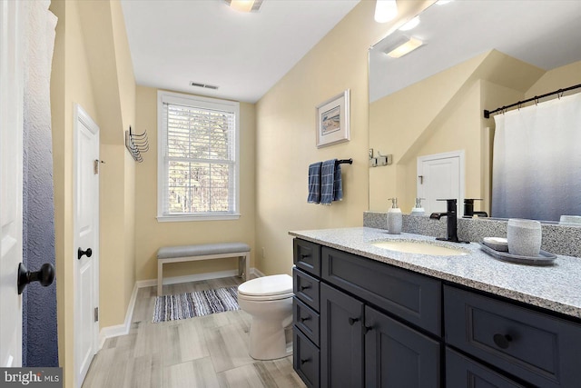 full bath with visible vents, baseboards, toilet, and vanity