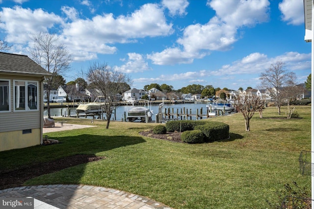 view of yard featuring boat lift, a boat dock, and a water view