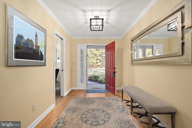 foyer entrance with ornamental molding, baseboards, and wood finished floors