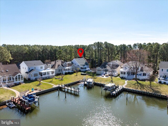 aerial view featuring a forest view, a residential view, and a water view