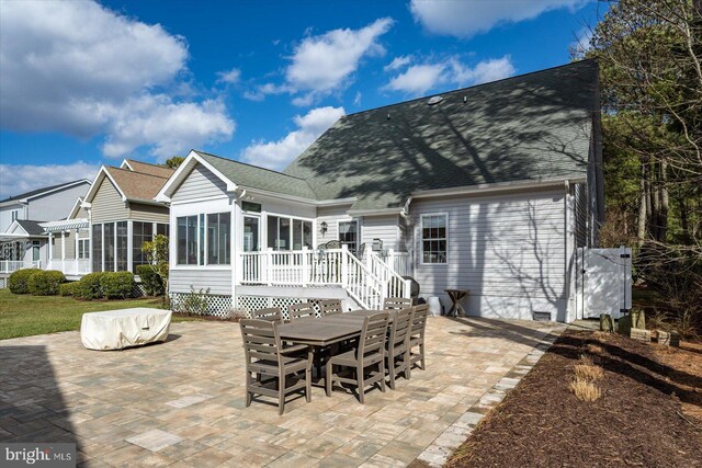 back of property with a patio area, a sunroom, and roof with shingles