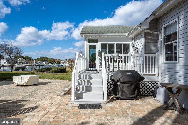 view of patio featuring a deck, area for grilling, and a sunroom