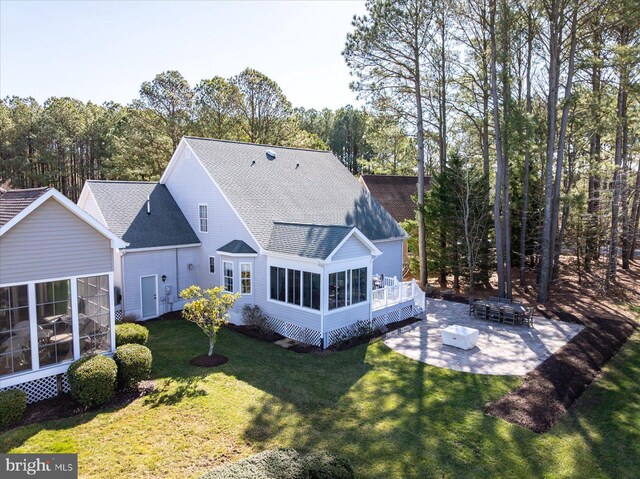 back of property featuring a patio, roof with shingles, a wooden deck, a yard, and a sunroom