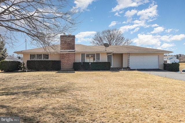 ranch-style house featuring driveway, a chimney, a front lawn, a garage, and brick siding