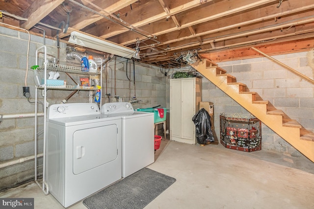 unfinished basement featuring stairs and separate washer and dryer