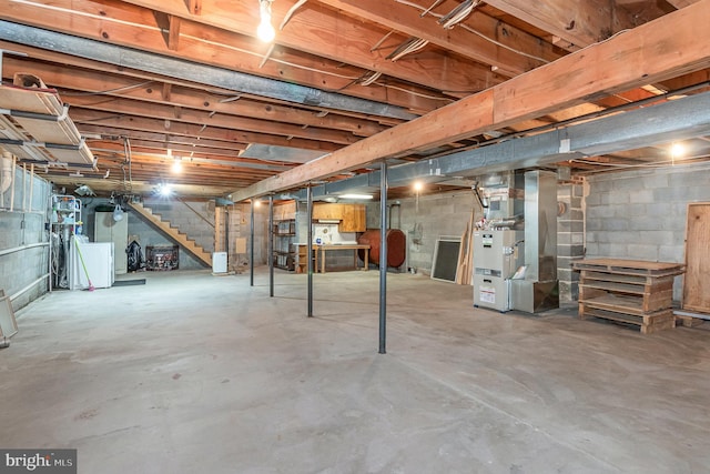 unfinished below grade area featuring stairs, washer / dryer, and heating unit