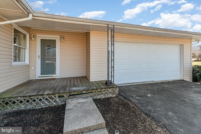 doorway to property with driveway and an attached garage