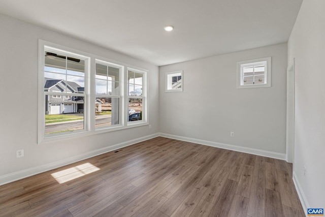 empty room with visible vents, baseboards, and wood finished floors