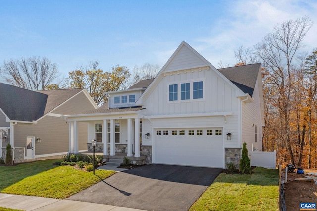 view of front of home with stone siding, a porch, driveway, and board and batten siding