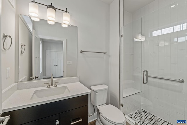 full bathroom featuring a shower stall, toilet, and vanity