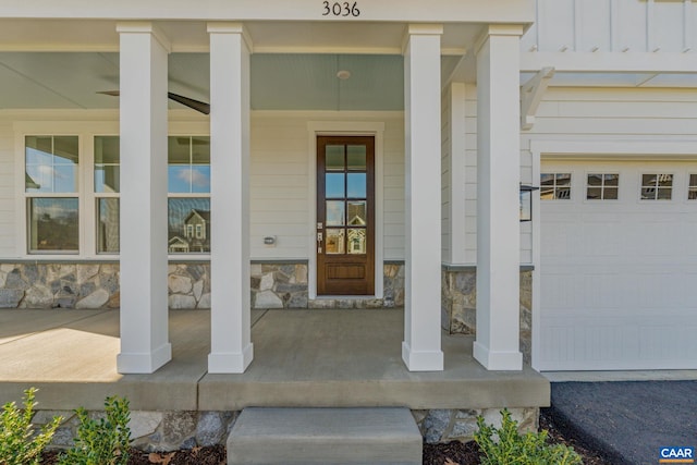 entrance to property with stone siding, a porch, and board and batten siding