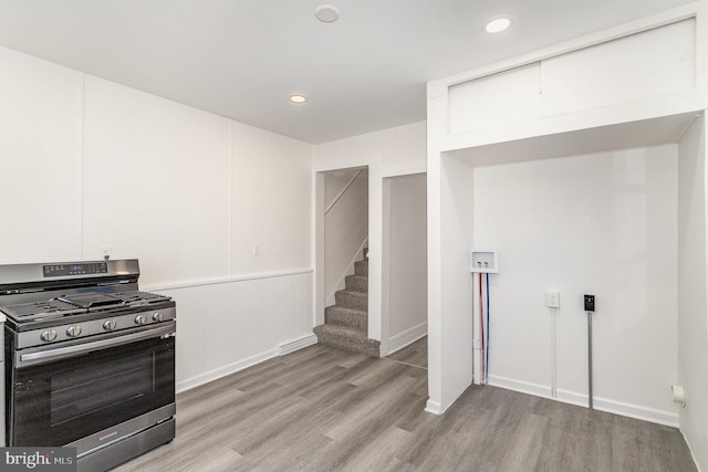 kitchen featuring recessed lighting, stainless steel range with gas cooktop, light wood-style flooring, and white cabinetry