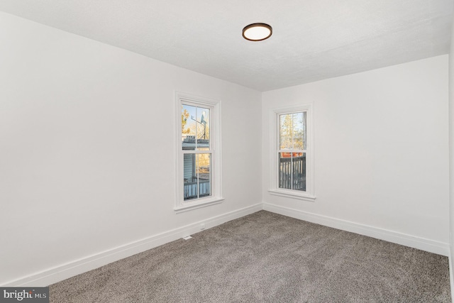 empty room featuring baseboards and carpet floors