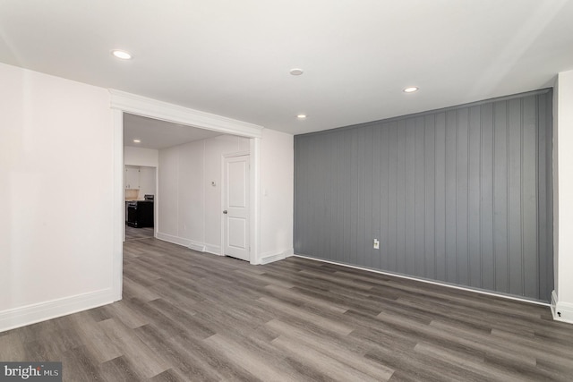 spare room featuring recessed lighting, wood finished floors, and baseboards