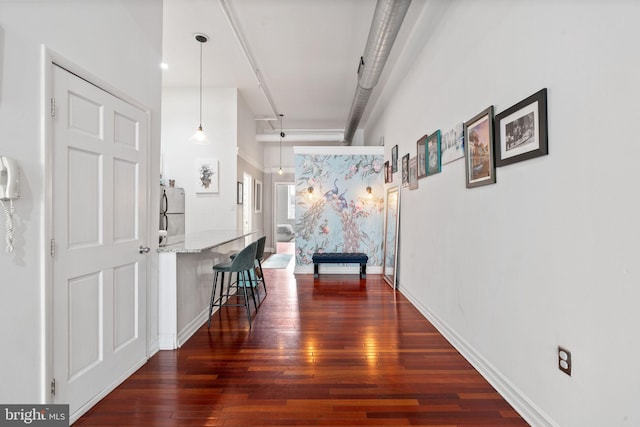 hall with baseboards and wood-type flooring