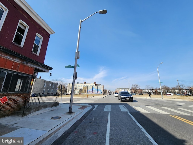 view of road with curbs, street lighting, and sidewalks