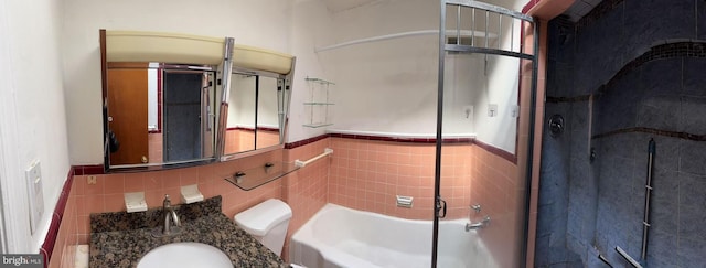 bathroom with vanity, tile walls, an enclosed shower, and a washtub