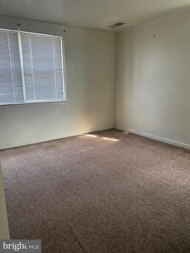 spare room featuring carpet flooring and visible vents