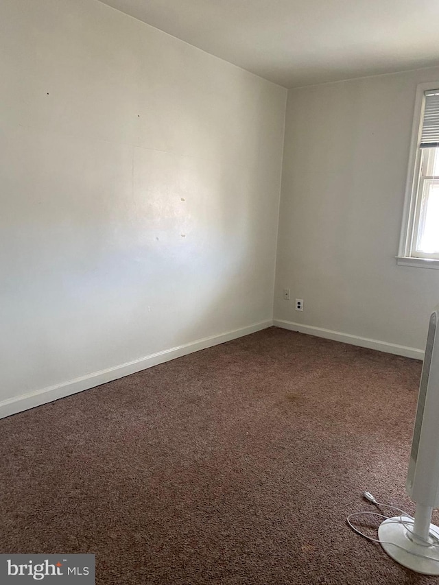 empty room with baseboards and carpet floors