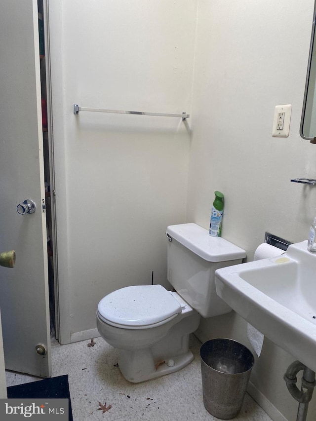 half bath with toilet and speckled floor