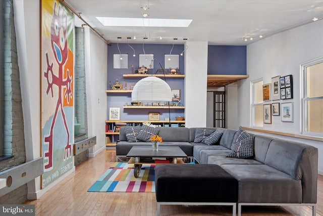 living room with a skylight and wood finished floors