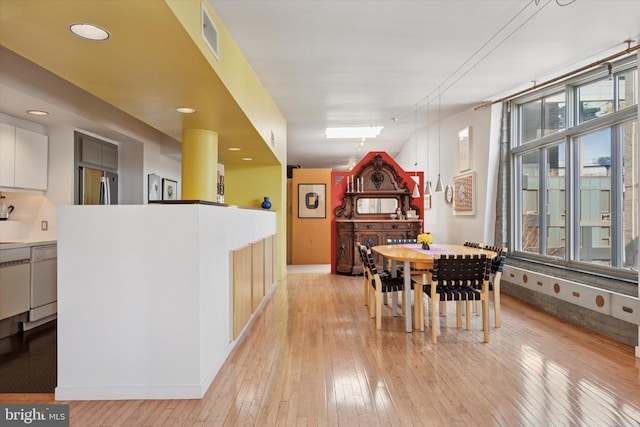 dining room with light wood-style flooring, baseboards, and visible vents