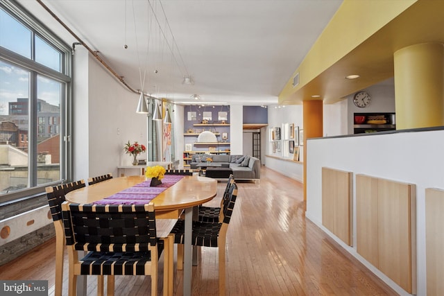 dining area featuring light wood-type flooring and visible vents