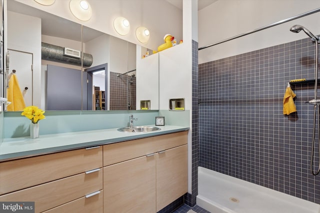 full bath featuring vanity and a tile shower