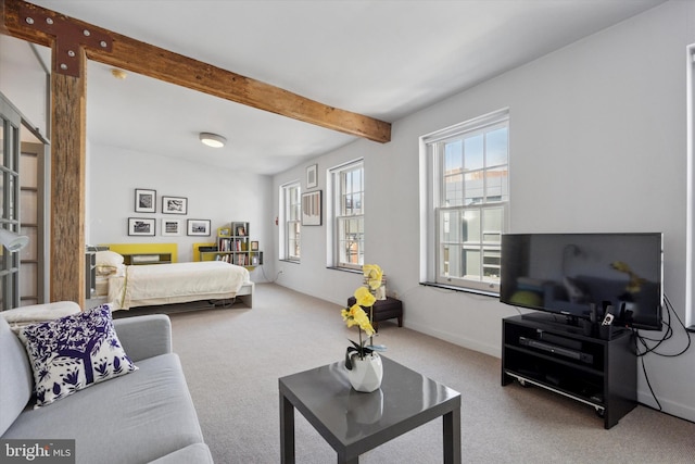 bedroom with baseboards, beam ceiling, and carpet flooring