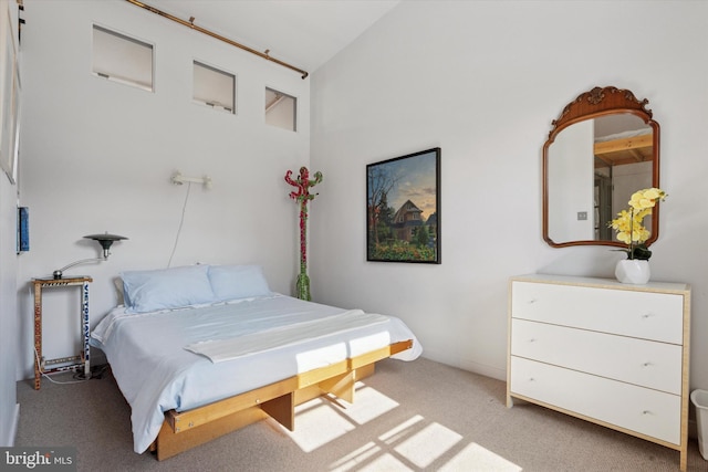 bedroom featuring vaulted ceiling and light carpet