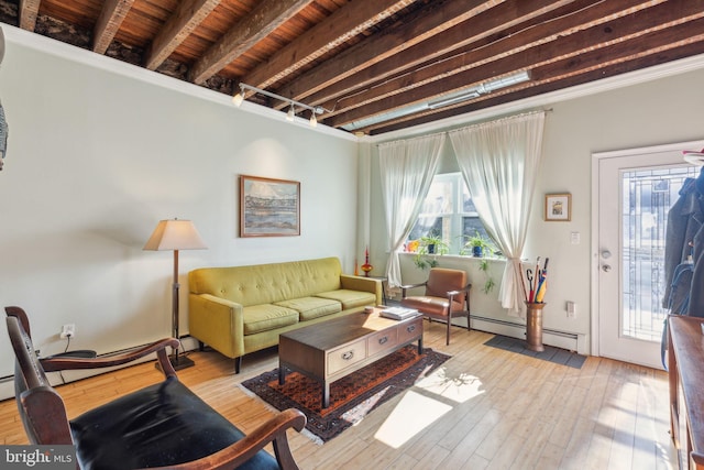 living area with beamed ceiling, a healthy amount of sunlight, a baseboard radiator, and wood finished floors