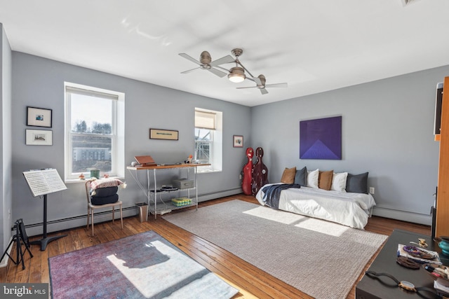 bedroom with a baseboard radiator, wood-type flooring, baseboard heating, and a ceiling fan