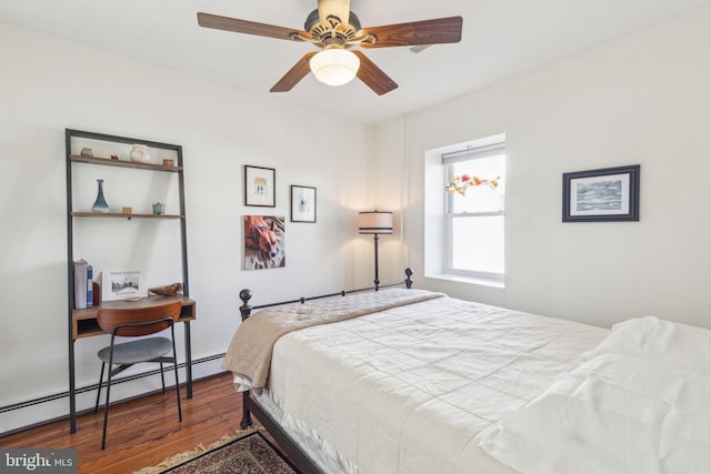 bedroom featuring a baseboard heating unit and wood finished floors