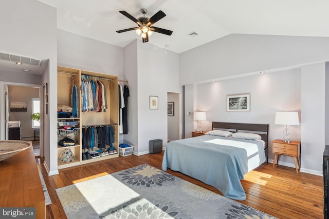 bedroom with hardwood / wood-style floors, baseboards, visible vents, and a closet