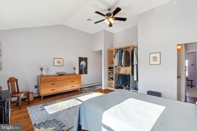 bedroom featuring visible vents, wood finished floors, a closet, a baseboard radiator, and vaulted ceiling