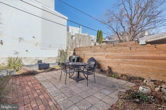 view of patio with outdoor dining area and fence