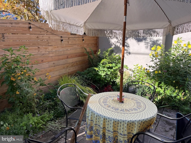 view of patio with outdoor dining space and fence