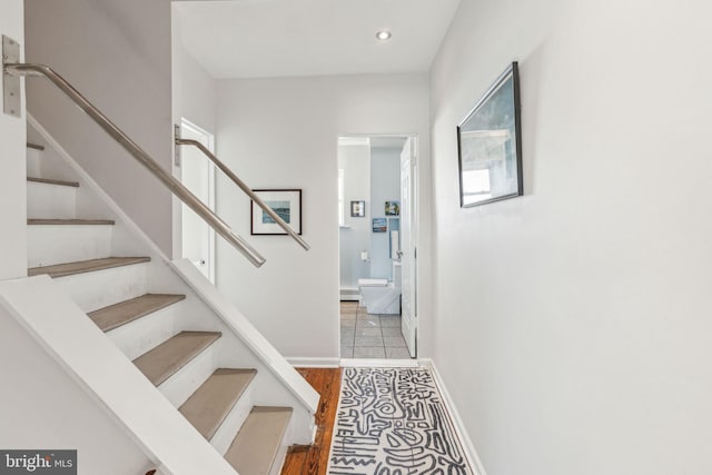 stairs featuring recessed lighting, wood finished floors, and baseboards