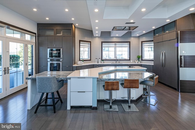 kitchen with a breakfast bar area, modern cabinets, and a sink