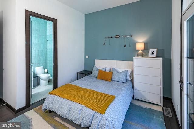 bedroom featuring baseboards, visible vents, and connected bathroom