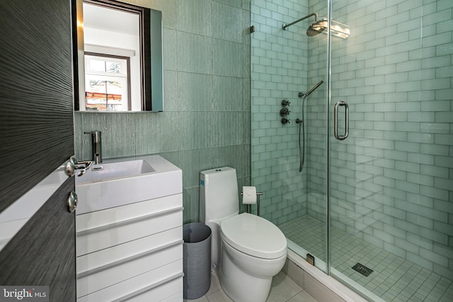 full bathroom featuring toilet, tile walls, a stall shower, and vanity