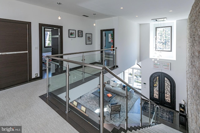 staircase featuring french doors, visible vents, and arched walkways