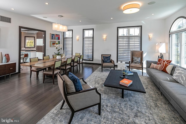 living room with recessed lighting, wood finished floors, and visible vents