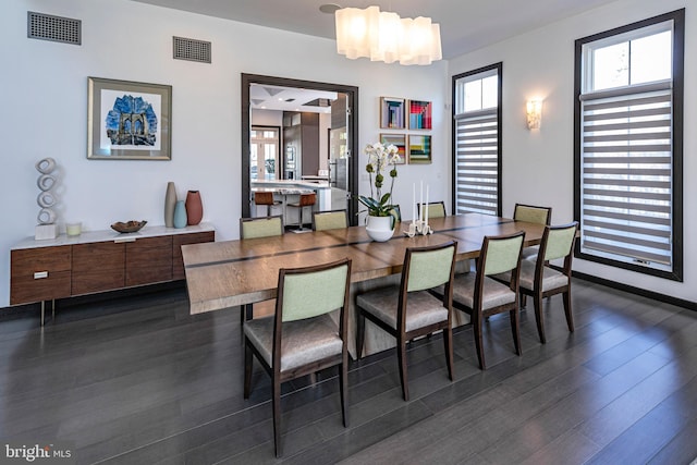 dining space featuring dark wood-type flooring and visible vents