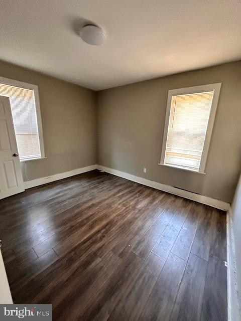 unfurnished room featuring dark wood finished floors and baseboards